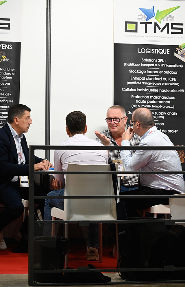 Group of men sitting at a table behind a barrier
