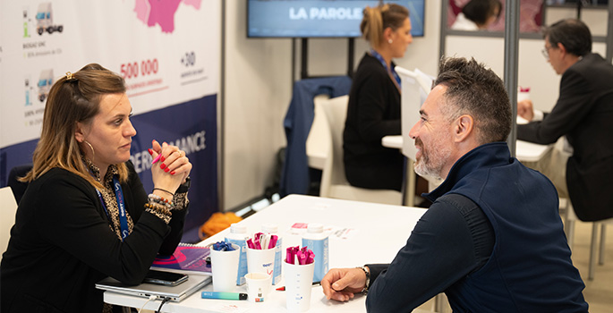 A man and a woman sitting in front of a map of France
