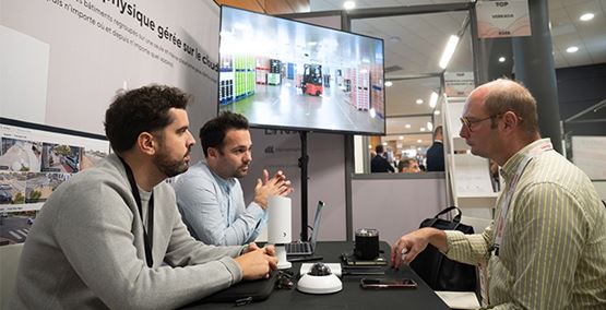 Hommes assis devant un écran montrant une usine