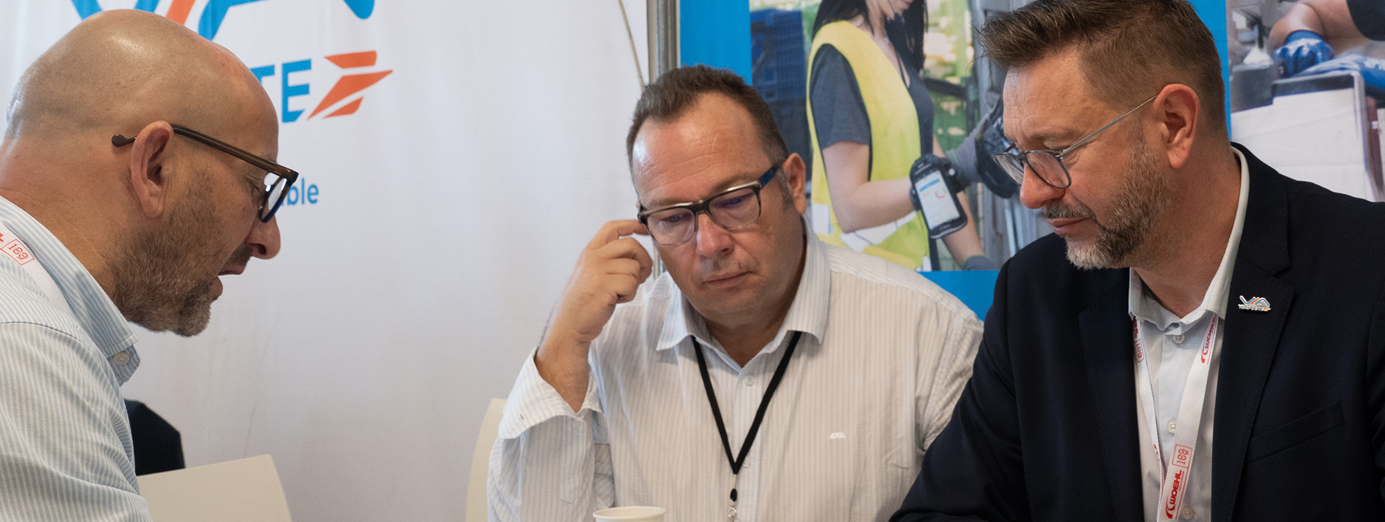 Hommes devant des affiches d'ouvriers et un fond blanc