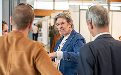Plusieurs personnes se rencontrent dans les couloirs du salon