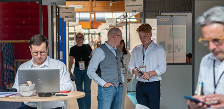 Visitors walking between booths at the trade show