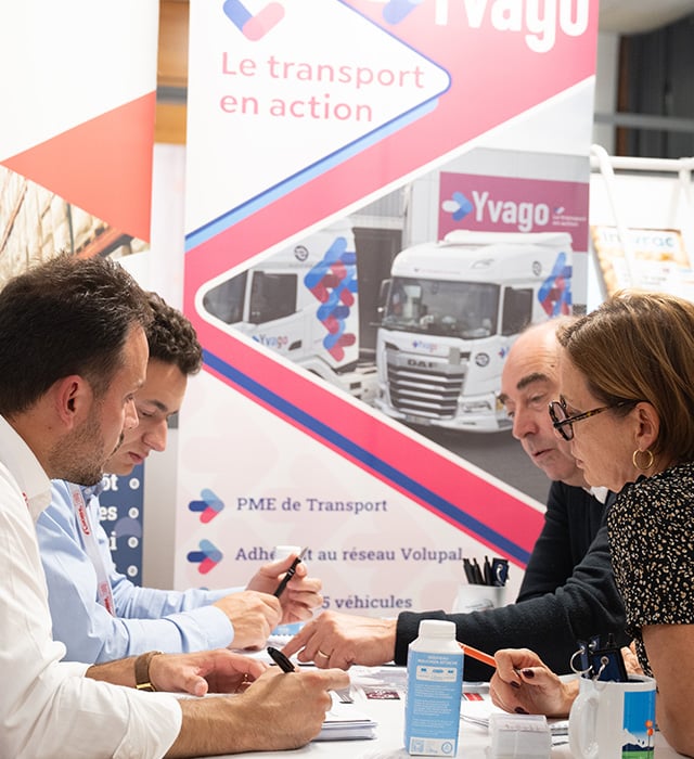 Professionnels discutant à leur stand de logistique