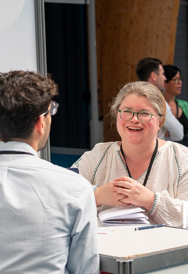 Femme souriant face à un invité
