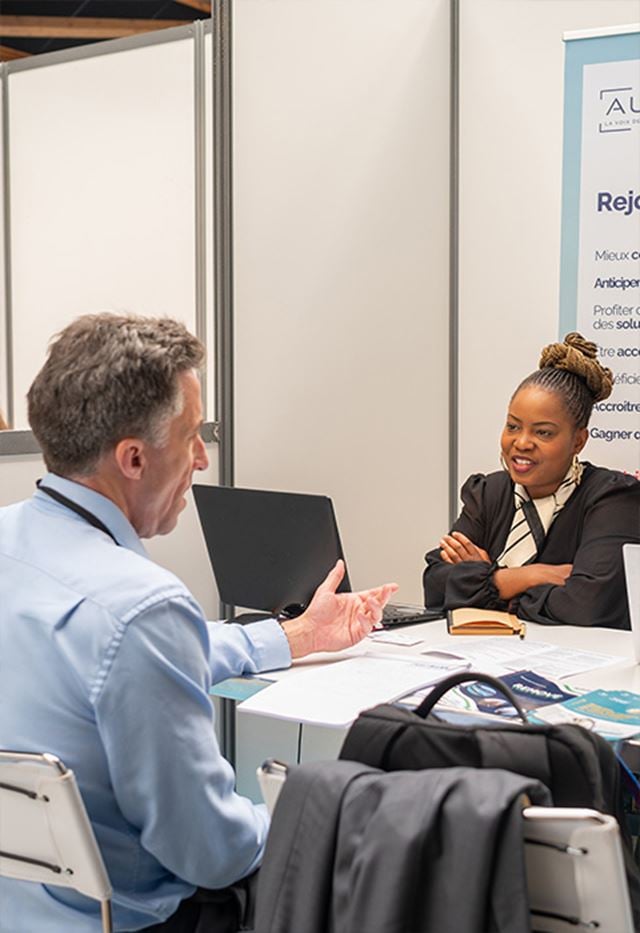 Femme souriant à un client dans un stand