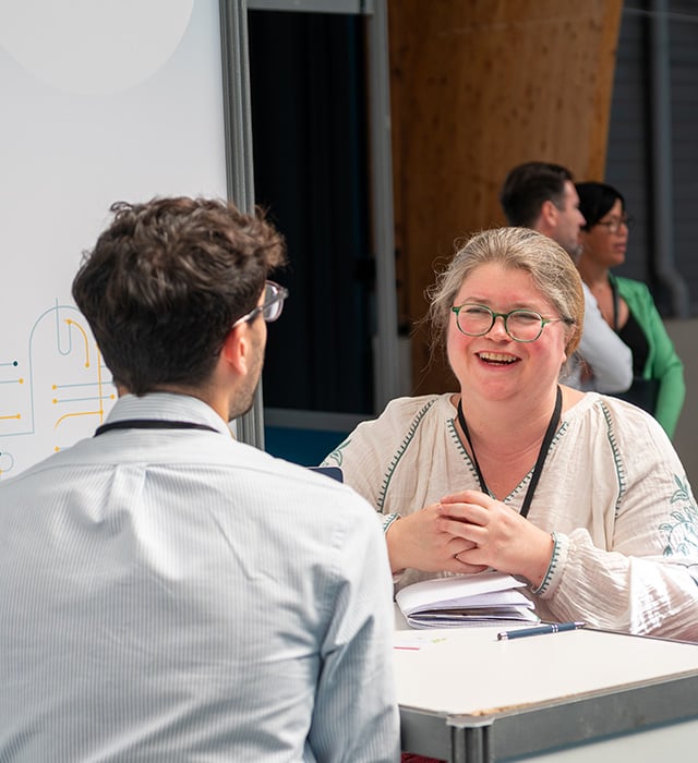 Femme souriant face à un invité