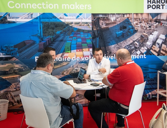 Participants de Top Transport Europe en pleine réunion à un stand. 