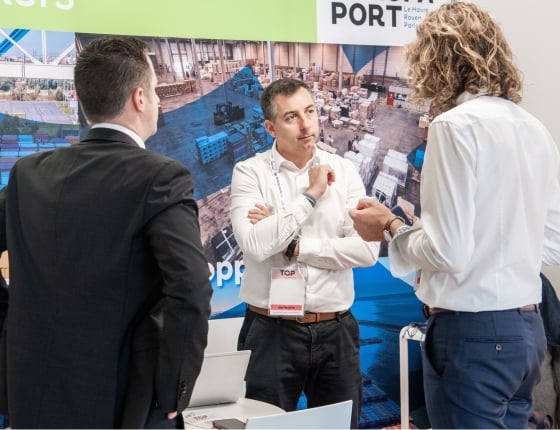 Des fournisseurs de solutions transports et des chargeurs parlent lors de Top Transport Europe sur un stand
