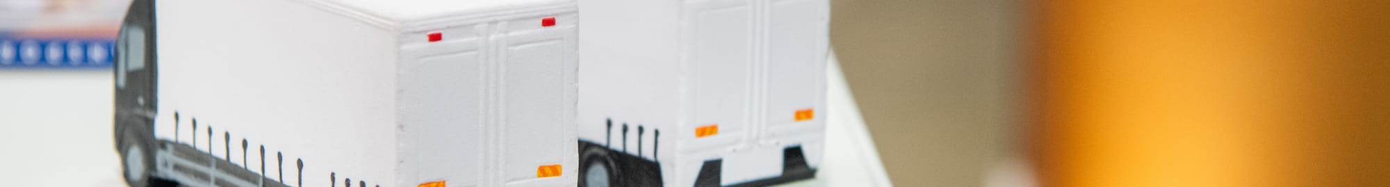 Deux figurines représentant des camions sur le stand d'un partenaire à Top Transport Europe 2023 